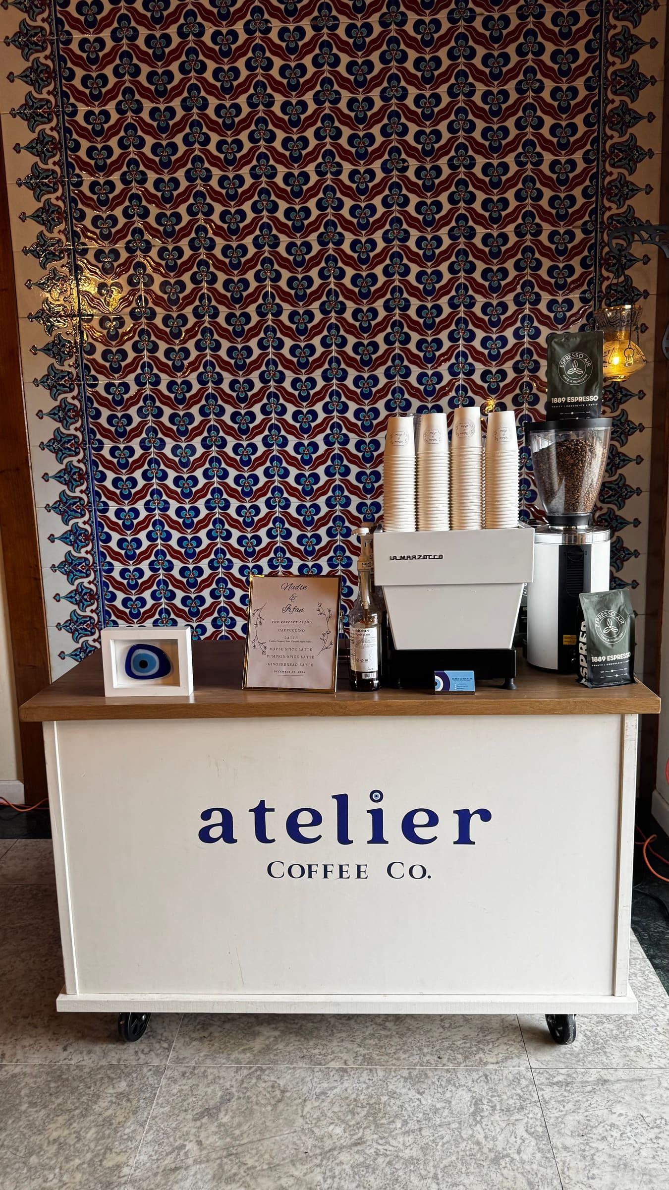 The Atelier Coffee Co. cart with a stack of cups and the blue nazar, in front of a patterned Turkish textile backdrop