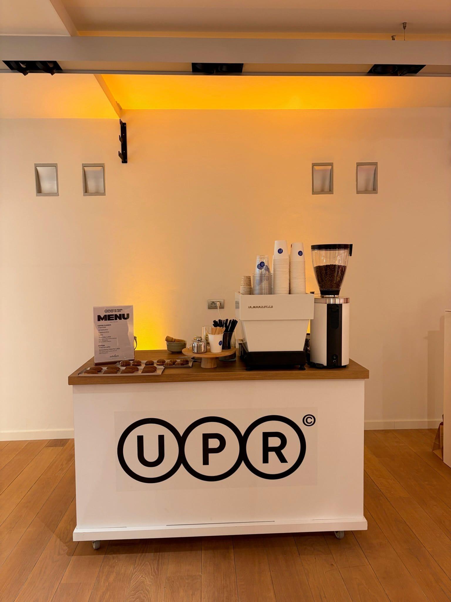 A branded espresso cart set up with a menu and grinder under warm light