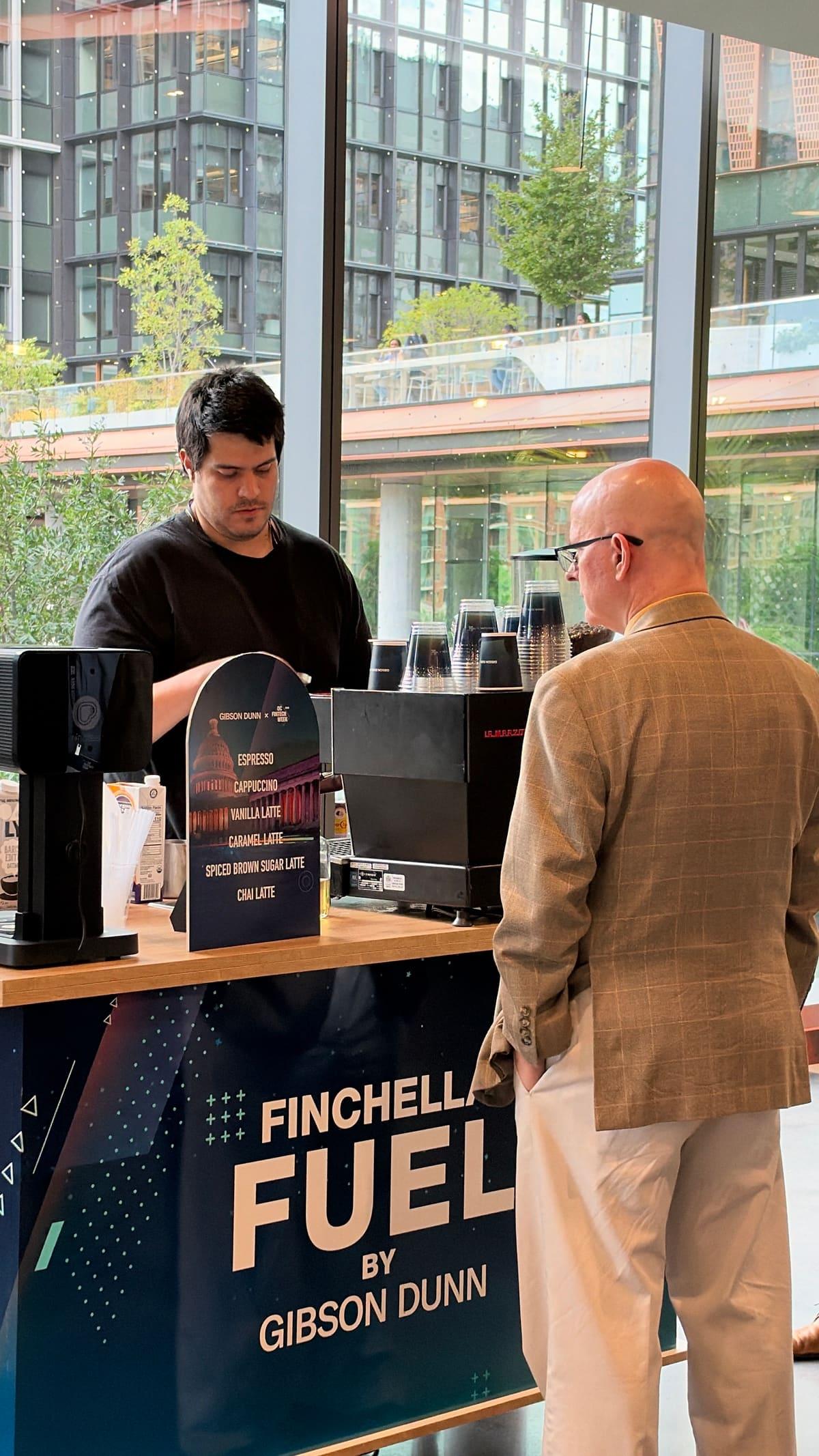An Atelier barista making a drink for a guest at a branded conference cart